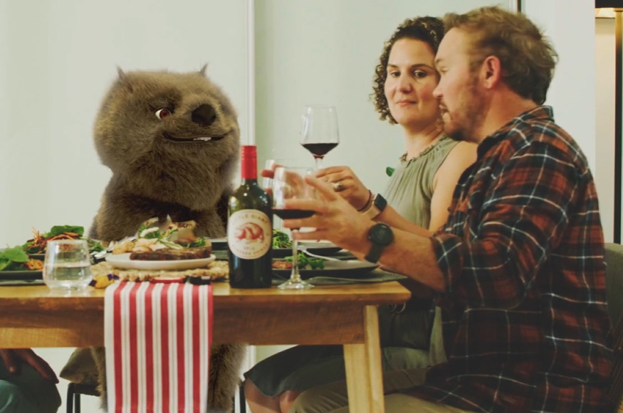 A wombat sitting at a table at a dinner party